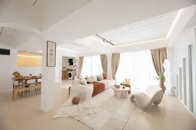 a white living room with a couch and a table at Ratchada Retreat Boutique Suites in Bangkok