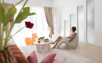 a woman sitting in a chair in a living room at Ratchada Retreat Boutique Suites in Bangkok
