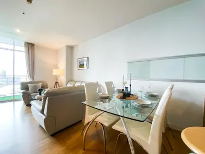 a living room with a glass table and a couch at Downtown View 65 SQM - Ultra Fast Wifi - Sathorn in Bangkok