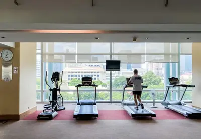 a man exercising on treadmills in a gym at Downtown View 65 SQM - Ultra Fast Wifi - Sathorn in Bangkok