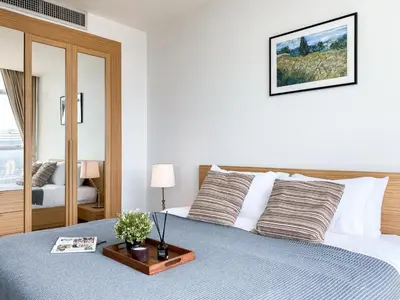 a bedroom with a bed with a blue comforter at Downtown View 65 SQM - Ultra Fast Wifi - Sathorn in Bangkok