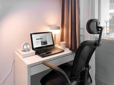 a laptop computer sitting on a desk with a chair at Exclusive Modern Apt - Ultra Fast WiFi - Thong Lo in Bangkok