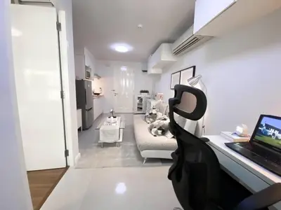 a living room with a laptop on a desk at Exclusive Modern Apt - Ultra Fast WiFi - Thong Lo in Bangkok