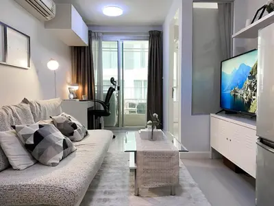 a living room with a couch and a flat screen tv at Exclusive Modern Apt - Ultra Fast WiFi - Thong Lo in Bangkok