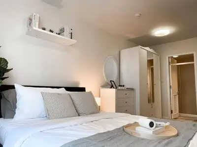 a bedroom with a white bed with a tray on it at Exclusive Modern Apt - Ultra Fast WiFi - Thong Lo in Bangkok