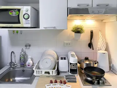 a kitchen with a sink and a counter top at Exclusive Modern Apt - Ultra Fast WiFi - Thong Lo in Bangkok