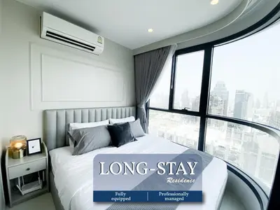 a long stay room with a bed and a large window at Luxury Skyview 1BR - Ultra Fast WiFi - Chit Lom in Bangkok