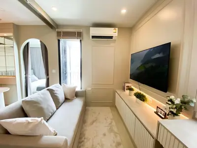 a living room with a white couch and a large tv at Luxury Skyview 1BR - Ultra Fast WiFi - Chit Lom in Bangkok