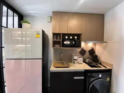 a kitchen with a white refrigerator and a stove at Luxury Skyview 1BR - Ultra Fast WiFi - Chit Lom in Bangkok