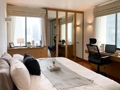 a bedroom with a bed and a desk with a computer at Luxury Modern 2BR 145 sqm - BTS Asok - Ultra Fast WiFi in Bangkok