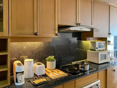 a kitchen with wooden cabinets and a counter top with appliances at Luxury Modern 2BR 145 sqm - BTS Asok - Ultra Fast WiFi in Bangkok