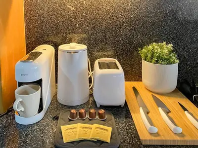 a counter with two coffee makers and a cutting board at Luxury Modern 2BR 145 sqm - BTS Asok - Ultra Fast WiFi in Bangkok