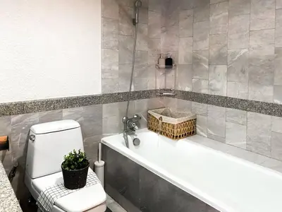 a bathroom with a white tub and a toilet at Luxury Modern 2BR 145 sqm - BTS Asok - Ultra Fast WiFi in Bangkok