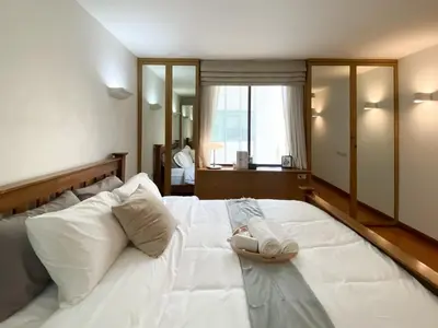 a large white bed with a pair of shoes on it at Luxury Modern 2BR 145 sqm - BTS Asok - Ultra Fast WiFi in Bangkok
