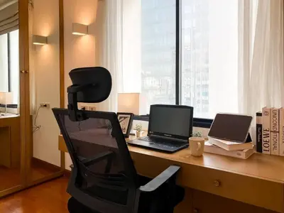 an office with a desk with a laptop and a chair at Luxury Modern 2BR 145 sqm - BTS Asok - Ultra Fast WiFi in Bangkok