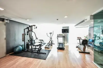 a gym with treadmills and exercise bikes in a room at Tropical Paradise 1BR - Ultra Fast Wifi - Thong Lo in Bangkok
