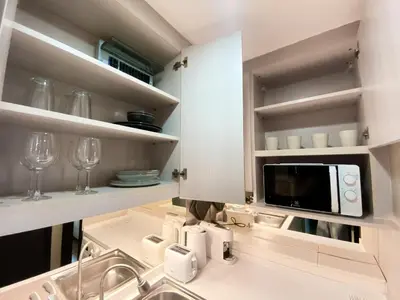 a kitchen with a sink and a microwave at Tropical Paradise 1BR - Ultra Fast Wifi - Thong Lo in Bangkok