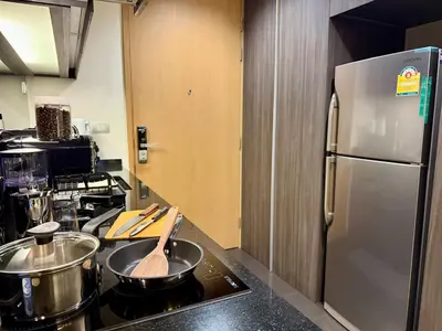 a kitchen with a stove and a stainless steel refrigerator at Cozy Spacious 1BR 3pax GardenView, 700m BTS ThongLo, Samitivej, SKV49, Fast wifi in Bangkok