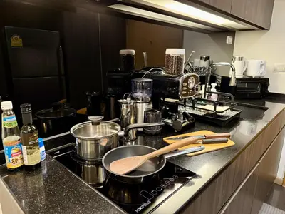a kitchen counter with pots and pans on a stove at Cozy Spacious 1BR 3pax GardenView, 700m BTS ThongLo, Samitivej, SKV49, Fast wifi in Bangkok