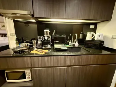a kitchen with a counter top with a microwave at Cozy Spacious 1BR 3pax GardenView, 700m BTS ThongLo, Samitivej, SKV49, Fast wifi in Bangkok