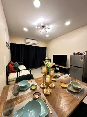 a wooden table with plates on it in a living room at Twenty-one BKK House in Bang Kapi