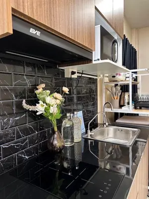 a kitchen with a sink and a vase of flowers on a counter at Twenty-one BKK House in Bang Kapi