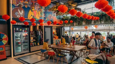 a group of people sitting at tables in a restaurant at Lub d Bangkok Chinatown - Steps from Sam Yod MRT Station in Bangkok