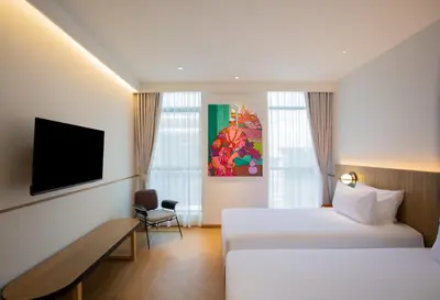 a hotel room with two beds and a tv at Lub d Bangkok Chinatown - Steps from Sam Yod MRT Station in Bangkok