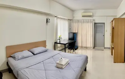 a bedroom with a large bed and a desk at Grand Residence in Bangkok