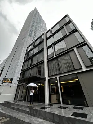 a person holding an umbrella in front of a building at T2 The Portal Sukhumvit in Bangkok
