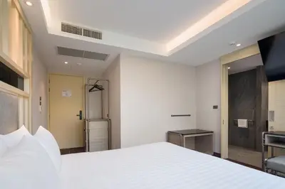 a bedroom with a white bed and a bathroom at T2 The Portal Sukhumvit in Bangkok