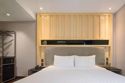 a bedroom with a large bed with a headboard at T2 The Portal Sukhumvit in Bangkok