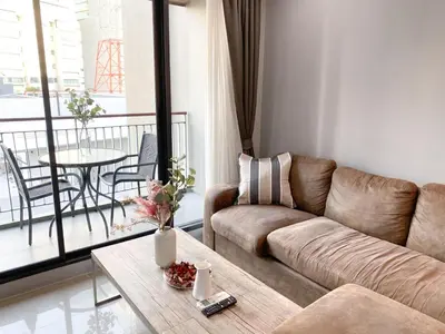 a living room with a couch and a table at 2Br Modern Comfort at Vibrant Asok BTS Station in Bangkok