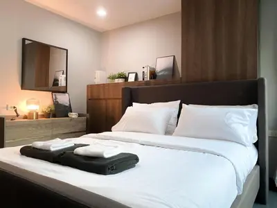 a bedroom with a large bed with towels on it at 2Br Modern Comfort at Vibrant Asok BTS Station in Bangkok