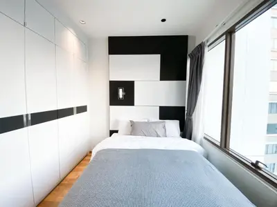a bedroom with a bed and a large window at The Grand Penthouse 2BR Ultra Fast WiFi Sukhumvit in Bangkok