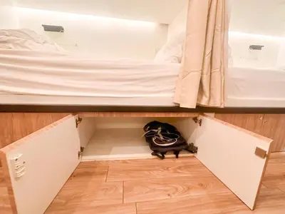 a black cat is sitting in the middle of a closet at Bangkok Neighborhood Hostel in Bangkok