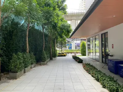 a walkway in front of a building with trees at 35 Bow Hotel in Ban Bang Bamru