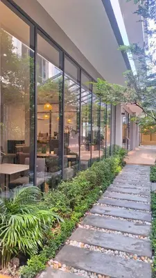 a walkway in front of a building with plants at 35 Bow Hotel in Ban Bang Bamru
