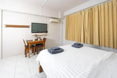 a bedroom with a bed and a desk and a television at Tom Guest House ทอมส์ เกสต์เฮ้าส์ in Thung Maha Mek