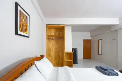 a bedroom with a bed and a wooden headboard at Tom Guest House ทอมส์ เกสต์เฮ้าส์ in Thung Maha Mek