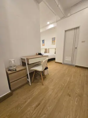 a room with a desk with a chair and a bed at Vevey Mansion in Bangkok
