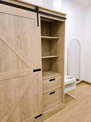 a wardrobe with a wooden door in a room at Vevey Mansion in Bangkok