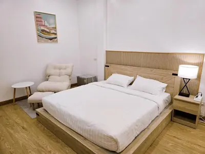 a bedroom with a large bed and a chair at Vevey Mansion in Bangkok