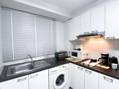 a kitchen with a sink and a washing machine at Contemporary 53 SQM - BTS Thong Lo - Ultra Fast WiFi in Bangkok