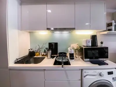 a kitchen counter with a sink and a microwave at Tropical Apartment- Ultra Fast WiFi- BTS Thong Lor in Bangkok