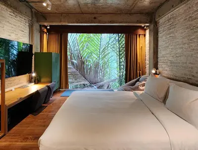 a bedroom with a large bed and a television at Hiddenwoods in Bang Chak