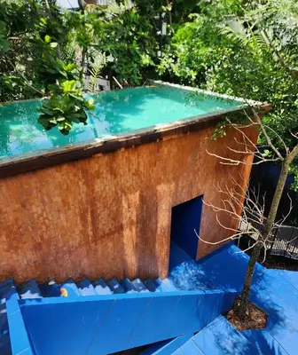 a house with a blue roof and a tree at Hiddenwoods in Bang Chak