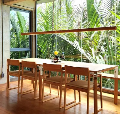 a dining room table with chairs and a large window at Hiddenwoods in Bang Chak