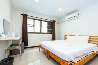 a bedroom with a bed and a desk and a window at xx The Hidden Sao Chingcha - เดอะ ฮิดเด้น เสาชิงช้า in Bangkok
