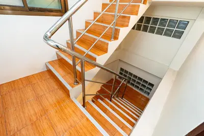 a staircase with wood flooring and metal railings at xx The Hidden Sao Chingcha - เดอะ ฮิดเด้น เสาชิงช้า in Bangkok